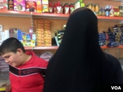 Safana demonstrates how they had to wear veils under IS, with their eyes, feet and hands covered. "We would trip on rocks," she said, laughing. Mosul, Iraq. June 8, 2017. (H. Murdock/VOA)