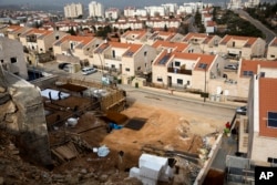 Palestinian men work at a construction site in the West Bank Jewish settlement of Ariel, Jan. 25, 2017.