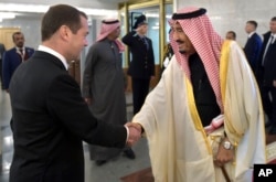 Russian Prime Minister Dmitry Medvedev, left, shakes hands with Saudi Arabia's King Salman during a meeting in Moscow, Russia, Oct. 6, 2017.