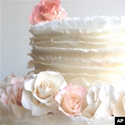 Maggie Austin innovated the frills, or ruffles, technique. The frills are created using paper-thin layers of fondant, which is a sugar paste, and are individually applied to the cake.