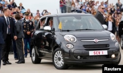 Pope Francis waves from a Fiat 500 model after being driven from Joint Base Andrews outside Washington, Sept. 22, 2015.