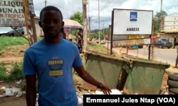 Derrière Francis, deux bacs à ordures à l'entrée du quartier, insuffisants pour tout le monde, à Yaoundé, au Cameroun, le 23 mai 2017. (VOA/Emmanuel Jules Ntap)