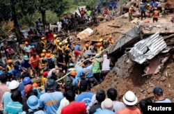 Rescuers search for people trapped in a landslide caused by Typhoon Mangkhut at a small-scale mining camp in Itogon, Benguet, in the Philippines, Sept. 17, 2018.