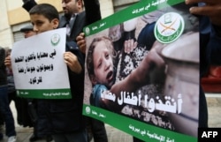 Children and Lebanese activists from the Islamic group Jamaa Islamiya hold a sit-in in solidarity with the Syrian besieged town of Madaya, outside the International Committee of the Red Cross (ICRC) headquarters in the Lebanese capital Beirut, Jan. 8, 201
