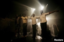 FILE - Malian band Songhoy Blues members, left to right, Nathanael Dembele, Garba Toure, Aliou Toure and Oumar Toure, react at the end of their concert at Village Underground in London, Britain, May 28, 2015.