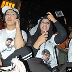 In this 2004 file photo, Kuwaiti women sitting in front of a screen use mobiles to vote for their national Bashar Al-Shatti who was competing for title of pan Arab entertainment program "Star Academy"