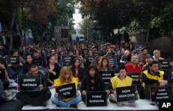 The students of Ankara University hold the placards with the names of those killed in Saturday's deadly explosions during a sit-in protest in Ankara, Turkey, Oct. 13, 2015.