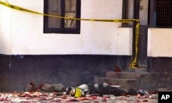 FILE - One of the bodies of three women who were shot dead by police lies outside the central police station in the coastal city of Mombasa, Kenya, Sept. 11, 2016.