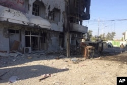 FILE - An Iraqi soldier inspects one of the damaged buildings after clashes between Iraqi security forces and members of the Islamic state in the city of Kirkuk, 180 miles (290 kilometers) north of Baghdad, Iraq, Oct, 22, 2016.