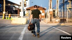 FILE - A steel worker returns to work after a being idle for two years at U.S. Steel Granite City Works in Granite City, Illinois, May 24, 2018.