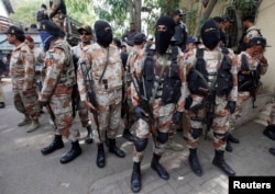 Paramilitary soldiers stand guard, as they present men (unseen), who were detained during Wednesday's raid on the Muttahida Qaumi Movement political party headquarters, before an anti-terrorism court in Karachi, March 13, 2015.