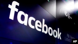 FILE - The logo for Facebook appears on screens at the Nasdaq MarketSite in New York's Times Square, March 29, 2018. 