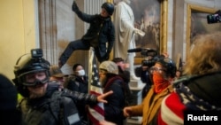 Para pendukung Presiden Donald Trump menyerbu Gedung Capitol pada aksi protes yang berakhir dengan kerusuhan di Washington DC (6/1). 