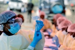 FILE - A health worker fills a syringe with Ebola vaccine before injecting it to a patient, in Goma, Democratic Republic of Congo, Aug. 5, 2019.