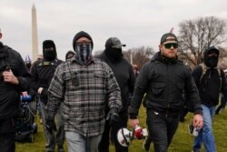 FILE - Proud Boy members Joseph Biggs, left, and Ethan Nordean, right with megaphone, walk toward the U.S. Capitol in Washington, Jan. 6, 2021.