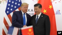 FILE - Then-President Donald Trump poses for a photo with Chinese President Xi Jinping during a meeting on the sidelines of the G20 summit in Osaka, Japan, on June 29, 2019.