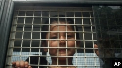 FILE - An ethnic Uighur boy inside a police van in Khlong Hoi Khong, Thailand is seen in this March 15, 2014 photo.