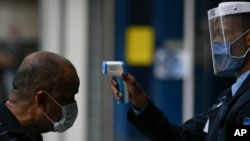 A man gets his temperature taken as a measure to curb the spread of the new coronavirus, at the entrance of El Recreo mall in Caracas, Venezuela, June 17, 2020. 