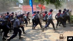 Polisi Myanmar dengan senjata pentungan mengejar para pemrotes di Letpadan, 140 kilometer sebelah utara Rangoon, Selasa (10/3).