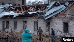 Residents walk at a site of a Russian missile strike, amid Russia's attack on Ukraine, in Dnipro, Ukraine, Nov. 21, 2024. 