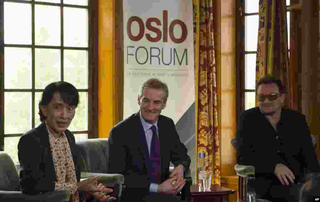 From left, Aung San Suu Kyi, Norway&#39;s Foreign Minister Jonas Gahr Stoere and Irish singer and activist Bono address the media after attending a conference of the Oslo Forum, Norway, June 18, 2012.
