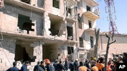 A handout picture released by the official Syrian Arab News Agency (SANA) shows rescue teams inspecting the blast scene in Aleppo March 18, 2012.