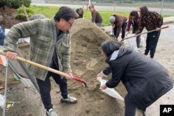 People fill sandbags in preparation for the next storms outside a public works station in South San Francisco, California, Jan. 3, 2023.