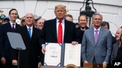President Donald Trump shows off a new North American trade agreement with Canada and Mexico, during an event at the White House, Jan. 29, 2020, in Washington. 