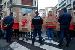 FILE - Members of Reporters Without Borders hold stencils representing portraits of imprisoned Turkish journalists, during a demonstration in front of the Turkish Embassy, in Paris, Jan. 5, 2018.