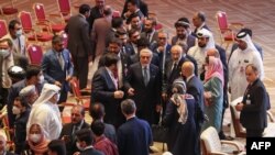 Abdullah Abdullah (C), Chairman of Afghanistan's High Council for National Reconciliation, speaks with members of delegations at the end of the session during the peace talks between the Afghan government and the Taliban in Doha, Sept. 12, 2020.