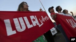 Supporters of Brazil's former President Luiz Inacio Lula da Silva, display banners saying "Free Lula" in Portuguese during a protest in front of the Superior Electoral Court, Brasilia, Aug. 31, 2018.