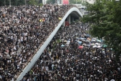 Protesters march along a road demonstrating against a proposed extradition bill in Hong Kong, China, June 12, 2019.