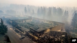 Smoke hangs over the scorched remains of Old Town Plaza following the wildfire in Paradise, California, Nov. 15, 2018. The shopping center housed a grocery store and other businesses.
