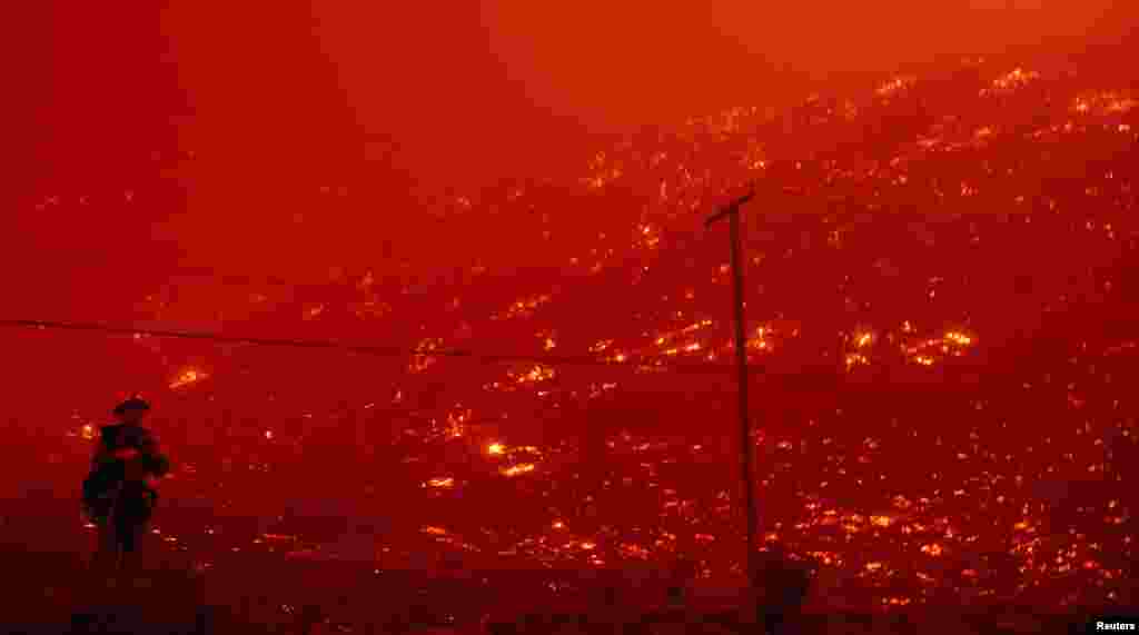 Petugas pemadam kebakaran berusaha memadamkan api yang membakar Hutan Nasional Angeles, sementara kebakaran hutan telah memusnahkan beberapa rumah di dekat wilayah Danau Hughes, negara bagian California, AS.