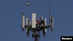 Radnici instaliraju 5G telekonunikacionu opremu na stubu T-Mobajl u Sibruku, Teksas, 6. maja 2020.