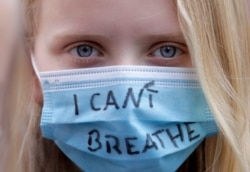 A young woman wears a face mark as people gather at the Alexander Platz in Berlin, Germany, June 6, 2020, to protest against the recent killing of George Floyd by police officers in Minneapolis.