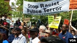 People march under a banner that reads "Stop Racist Police Terror," Baltimore, Maryland, May 2, 2015. (R. Muntu/VOA)