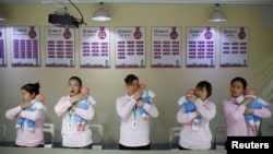 资料照：北京的一所阿姨训练学校在培训保姆如何照顾新生儿。（2018年12月5日）