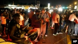 FILE - Protesters gather along West Florissant Avenue during demonstration in Ferguson, Missouri, Aug. 11, 2015.