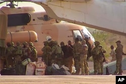 This undated photograph provided by the French military shows Russian mercenaries boarding a helicopter in northern Mali. (French Army via AP)