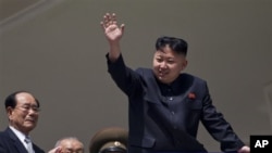 Pemimpin Korut, Kim Jong Un melambai kepada warga pada perayaan HUT ke-100 mendiang Kim Il Sung di Pyongyang, Minggu (15/4).