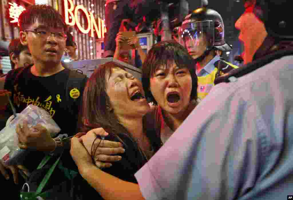Protesters cry as police officers try to stop them from blocking the road in the Mong Kok district of Hong Kong, Nov. 26, 2014.