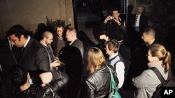 In this Thursday, December 29, 2011, file photo, workers from one of the US non-governmental organizations, the National Democratic Institute, wait as Egyptian officials raid their office in Cairo.