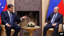 FILE - Venezuelan President Nicolas Maduro, left, gestures as he speaks to Russian President Vladimir Putin during meeting at the Novo-Ogaryovo residence outside in Moscow, Russia, Dec. 5, 2018.