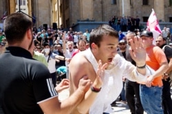 Opponents of the march push a man as they block off the capital's main avenue to an LGBT march in Tbilisi, Georgia, July 5, 2021.
