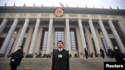 Security personnel stand guard in front of the Great Hall of the People during meetings ahead of tomorrow's opening ceremony of the National People's Congress (NPC), in Beijing, March 4, 2016. 