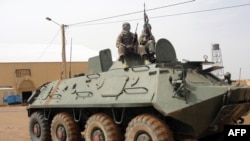 Des combattants du Mujao, groupe lié à Al-Qaïda au Maghreb Islamique (Aqmi), montent la garde sur un char abandonné par l'armée malienne, près de l'aéroport de Gao, au Mali, 7 août, 2012.