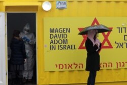 FILE - A woman waits outside a container at a coronavirus testing center while Israel is under a lockdown as part of the coronavirus disease restrictions, in Jerusalem Jan. 29, 2021.