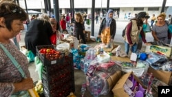 Migrants select among donated goods in the subway in front of Keleti railway station in Budapest, Hungary, Sunday, Sept. 6, 2015.