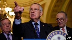 FILE - Senate Minority Leader Harry Reid of Nevada, flanked by Senate Minority Whip Richard Durbin of Illinois, left, and Senate Minority Leader-elect Charles Schumer of New York, answers questions from the media after the Democratic policy luncheon on Capitol Hill in Washington, Dec. 6, 2016.